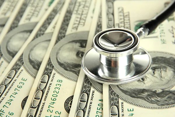 Healthcare cost concept: stethoscope and dollars isolated on white — Stock Photo, Image