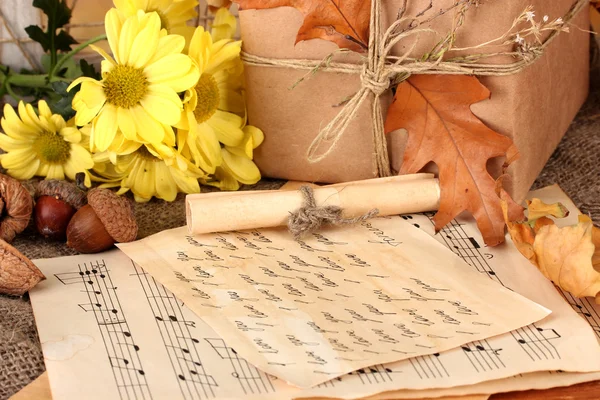 Composição outonal com notas folha, flores e folhas sobre fundo brilhante — Fotografia de Stock