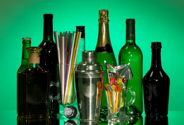 Sammlung von Getränken, Cocktailshaker und anderen Barkeeper-Geräten auf farbigem Hintergrund — Stockfoto