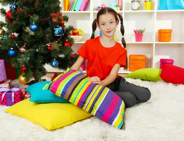 Menina sentada perto da árvore de Natal — Fotografia de Stock