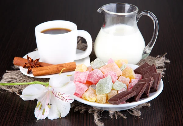 Šálek kávy s rahat potěšení a mléko na dřevěný stůl — Stock fotografie