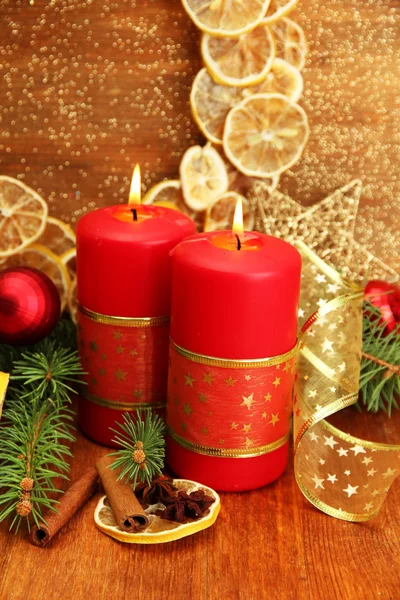 Two candles and christmas decorations, on golden background — Stock Photo, Image