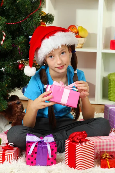 Little girl holding gift box near christmas tree Stock Photo