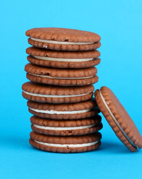 Biscotti al cioccolato con strato cremoso su sfondo blu — Foto Stock
