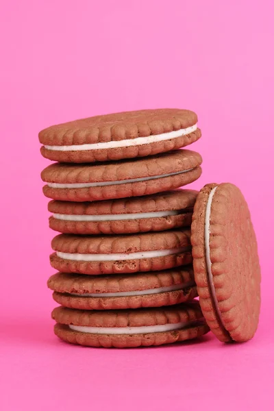 Czekoladowe ciasteczka z kremowe warstwy na różowym tle — Zdjęcie stockowe
