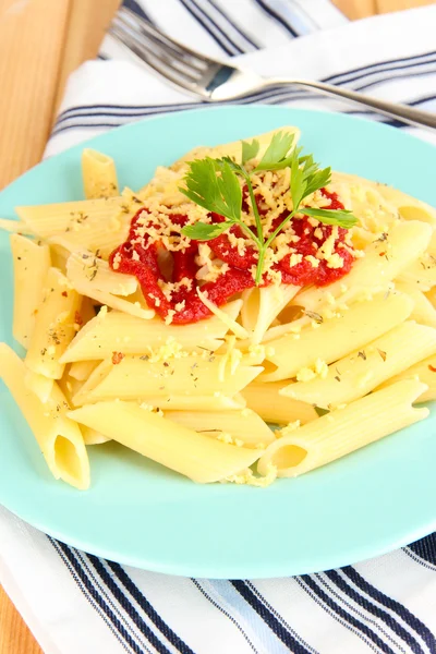 Piatto di pasta rigatoni con salsa di pomodoro sul tavolo di legno da vicino — Foto Stock