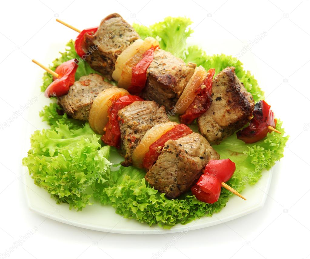 tasty grilled meat and vegetables on skewers on plate, isoalted on white