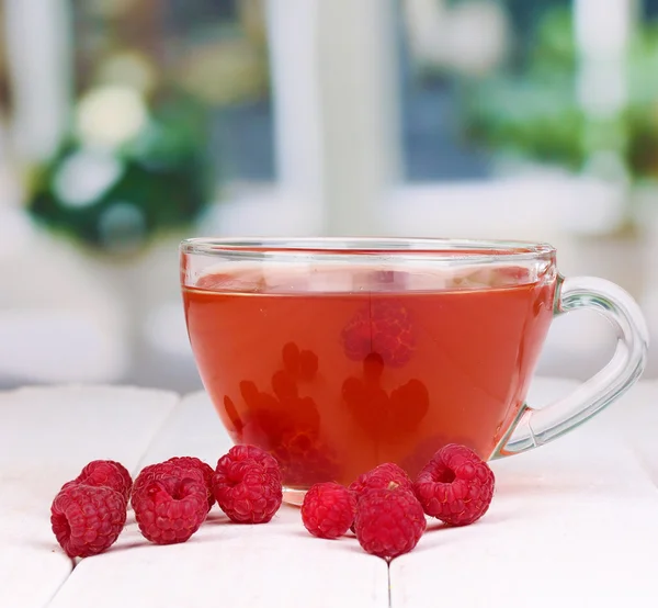 Tea with raspberries on table on bright background — Stock Photo, Image