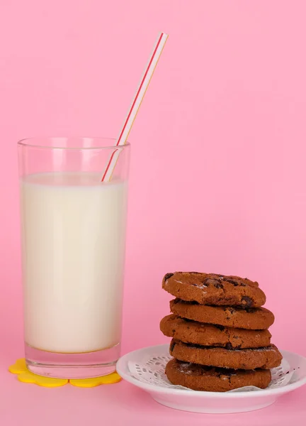 ピンク色の背景上にある cookie と新鮮な新しいミルクのガラス — ストック写真