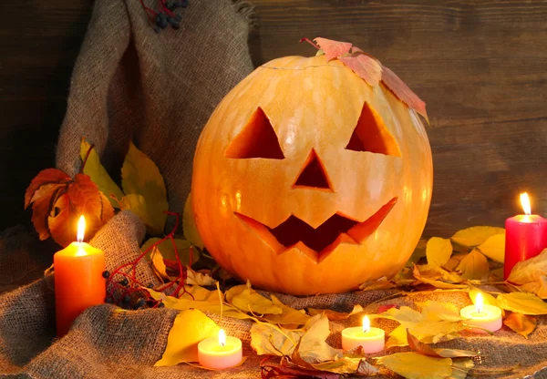 Halloween pumpa och höstlöv, på trä bakgrund — Stockfoto