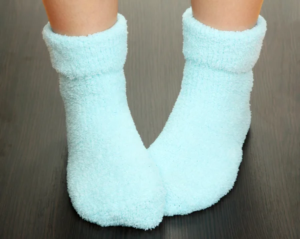 Pernas femininas em meias azuis no chão laminado — Fotografia de Stock
