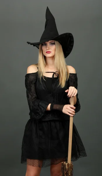 Halloween-Hexe mit Besen auf grauem Hintergrund — Stockfoto