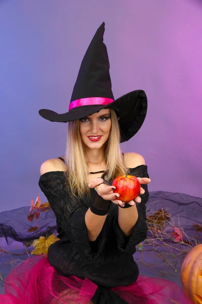 Bruja de Halloween con manzana roja sobre fondo de color —  Fotos de Stock