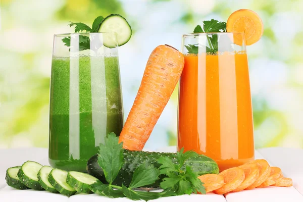 Jugos de verduras frescas sobre mesa de madera, sobre fondo verde — Foto de Stock