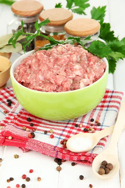 Bowl of raw ground meat with spices on wooden table — Stock Photo, Image