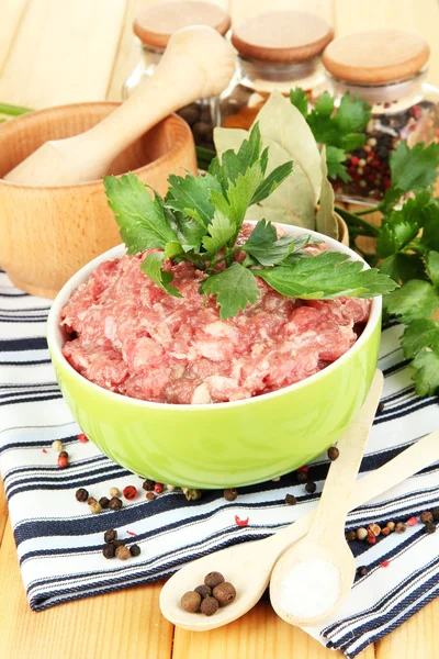 Bowl of raw ground meat with spices on wooden table — Stock Photo, Image