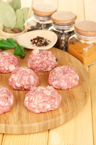 RAW köttbullar med kryddor på träbord — Stockfoto