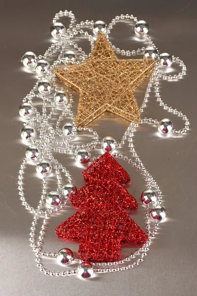 Stella di Natale, albero e perle su sfondo grigio — Foto Stock