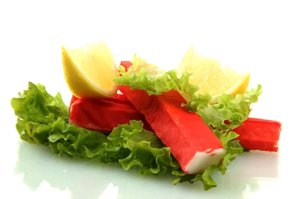 Palitos de cangrejo sobre hojas de lechuga con limón, aislados sobre blanco —  Fotos de Stock