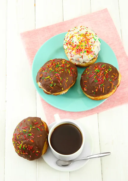 Leckere Donuts auf Farbteller auf hellem Holzhintergrund — Stockfoto