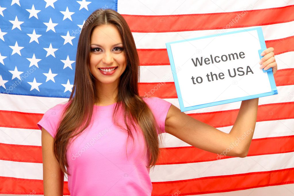 Young woman young woman holding tablet on background of American flag