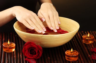 kadın eliyle su yaprakları kahverengi zemin üzerine ahşap kase