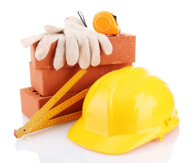 kask, rulet, tuğla ve üzerinde beyaz izole eldivenler