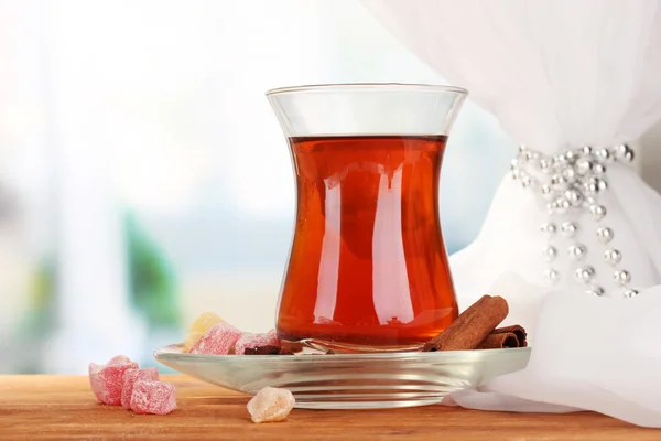 Glass of Turkish tea and rahat lokum, on wooden table — Stock Photo, Image