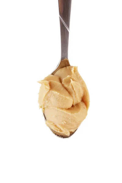 Delicious peanut butter in spoon isolated on white close-up — Stock Photo, Image