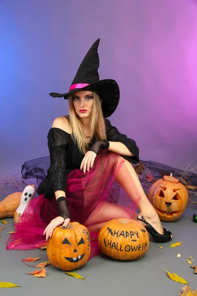 Strega di Halloween con zucche su sfondo di colore — Foto Stock