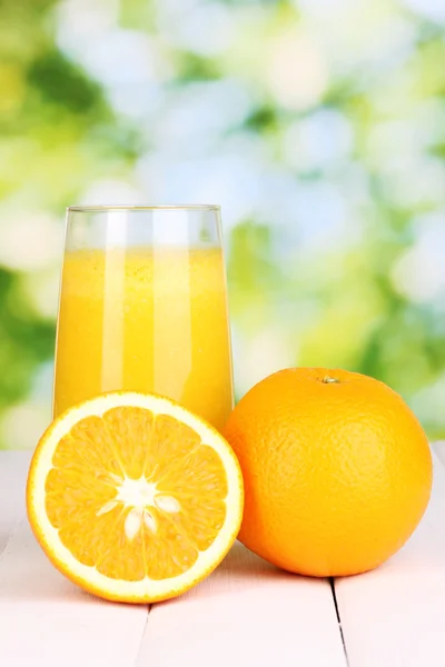 Copo de suco de laranja fresco na mesa de madeira, no fundo verde — Fotografia de Stock