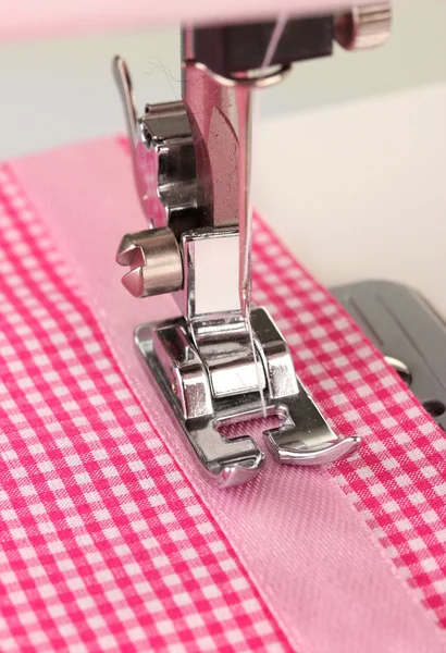 Close-up van naaimachine werkzaam deel met roze doek — Stockfoto