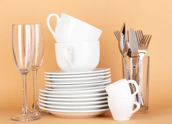 ベージュ色の背景上の白い皿をきれい — ストック写真