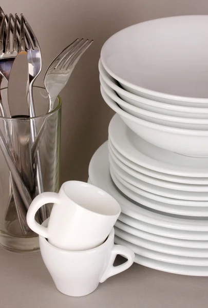 Gri zemin üzerine beyaz bulaşıkları temizle — Stok fotoğraf