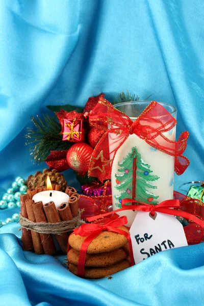 Galletas para Santa: Imagen conceptual de galletas de jengibre, leche y decoración navideña sobre fondo azul — Foto de Stock