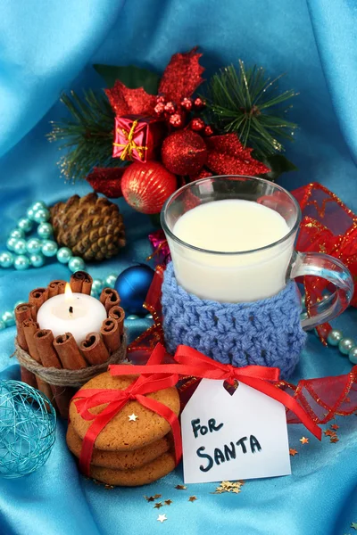 Galletas para Santa: Imagen conceptual de galletas de jengibre, leche y decoración navideña sobre fondo azul — Foto de Stock