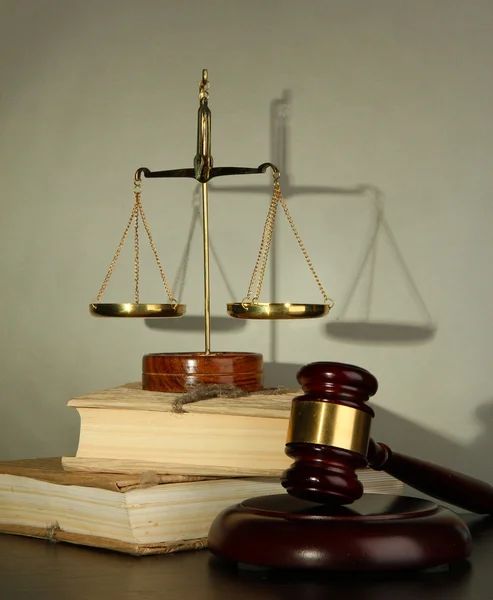 Golden scales of justice, gavel and books on grey background — Stock Photo, Image