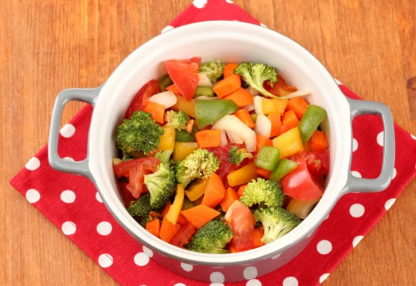 Vegetable stew in gray pot on color napkin on wooden background — Stock Photo, Image