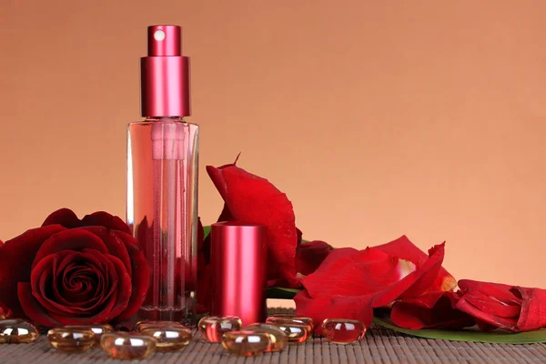 Vrouw perfume in mooie fles met roos op bruine achtergrond — Stockfoto