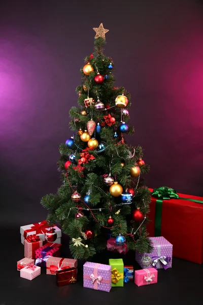 Geschmückter Weihnachtsbaum mit Geschenken auf dunklem Hintergrund — Stockfoto