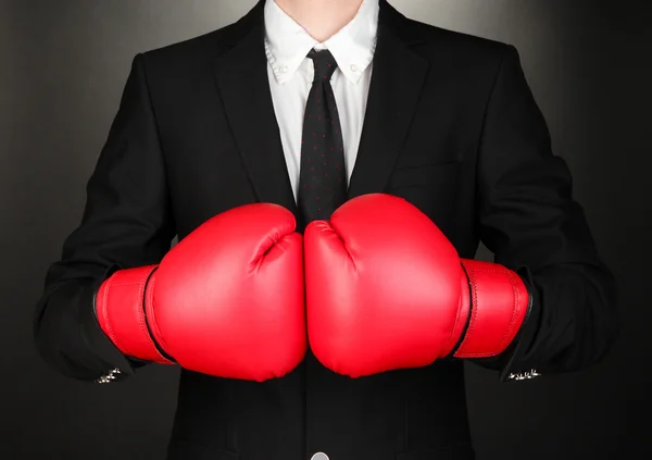 Empresário em luvas de boxe em fundo cinza — Fotografia de Stock