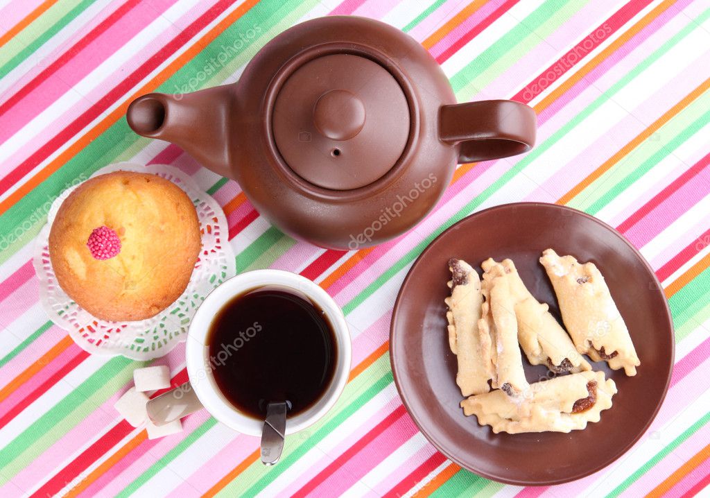 Top view of cup of tea and teapot on colorful tablecloths — Stock Photo