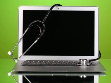 yansıma yeşil zemin üzerine bir stetoskop ile gümüş defter