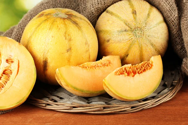 Geschnittene Melone Weidenmatte auf grünem Hintergrund Nahaufnahme — Stockfoto