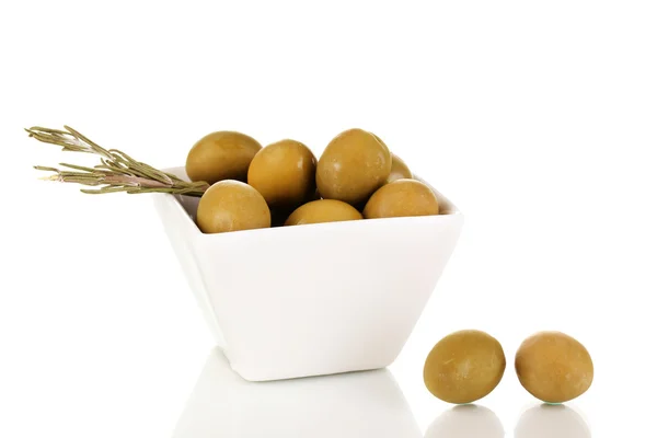 Gröna oliver i vit skål med rosmarin isolerad på vit — Stockfoto