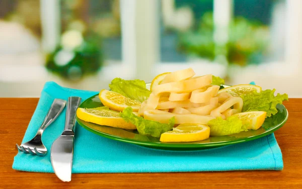 調理のイカ板のクローズ アップにレモンとレタスのリング — ストック写真