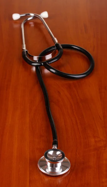 Stetoskop na brązowy drewniany stół — Zdjęcie stockowe