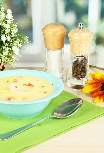 Sopa fragante en plato azul en la mesa en el fondo de la ventana primer plano — Foto de Stock