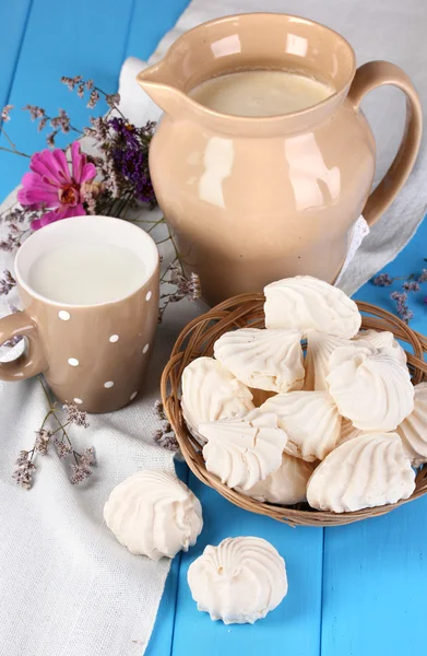 Jarra y taza de leche con merengues en mesa de madera de cerca — Foto de Stock