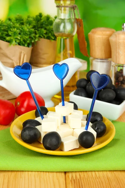 Feta ost kuber på tallrik med Oliver på träbord på naturliga bakgrund — Stockfoto